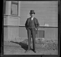 Wayne West stands at the side of the West's house, Los Angeles, about 1900