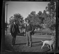 Guy M. West and Charles Rucher stand on the front lawn of the West residence, Los Angeles, about 1900