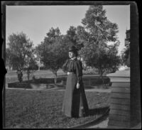 Nella West stands in the West's front yard, Los Angeles, about 1900