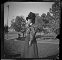 Nella West stands in the West's front yard, Los Angeles, about 1900