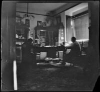 Wilson West and George M. West sit at a table in the library of the West's house at 240 South Griffin Avenue, Los Angeles, 1899