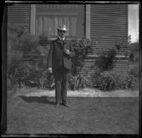 H. H. West poses next to the West's house, Los Angeles, about 1900