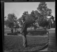 Charles Rucher and Wilson West stand on the West's front lawn, Los Angeles, about 1900
