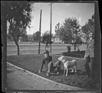 Wilson West sits on the West's front lawn with the neighbor's dog, while Wayne West stands by, Los Angeles, about 1900