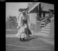 Eva Taylor chases after Elizabeth West on the West's front lawn, Los Angeles, about 1905