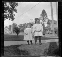 Frances and Elizabeth West stand on a front lawn, Los Angeles, about 1907