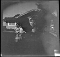 Elizabeth and Frances West stand in a washboiler in the backyard of the West's house, Los Angeles, about 1914