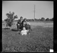John Teel, Mary A. West, Hattie Cline and baby Ambrose Cline pose in a field at John Teel's ranch, Los Angeles, [about 1915]