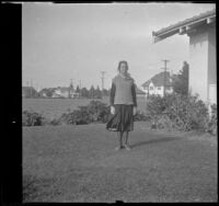 Elizabeth West stands in the front yard of the West's house at 1644 Wellington Road, Los Angeles, about 1919