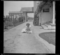 Elizabeth West plays jacks on the West's driveway, Los Angeles, about 1919