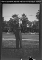 H. H. West Jr. stands on the front lawn of the West's house at 2223 Griffin Avenue wearing a Boy Scouts sweater, Los Angeles, about 1930