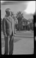H. H. West Jr. stands in the driveway of the West's house at 2223 Griffin Avenue wearing a suit, Los Angeles, about 1930