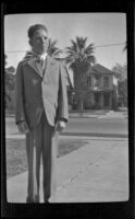 H. H. West Jr. stands in the driveway of the West's house at 2223 Griffin Avenue wearing a suit, Los Angeles, about 1930