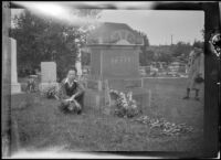 H. H. West Jr. kneels in front of Charles Teel's gravestone while Mertie West stands to the side, Los Angeles, about 1933