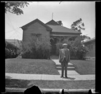 Wilson West stands on the sidewalk in front of 1919 North Hancock Street, Los Angeles, 1936
