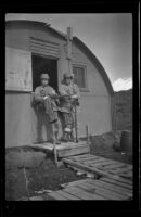 H. H. West, Jr. and a companion stand outside their quarters, Dutch Harbor, 1943