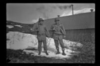 Two companions of H. H. West, Jr., pose in the snow outside the barracks, Dutch Harbor, 1943
