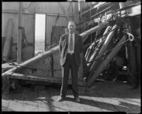 Man in a suit on the drill floor of an oil well, California, 1930-1939
