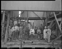 Portrait of workers and well-dressed men and women people on the drill floor of an oil well, Los Angeles, 1930-1940
