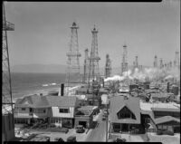 Venice oil field with beach cottages and the beach on the left, Los Angeles, circa 1930