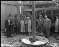 Group portrait of men and women on the drill floor an oil well at the Venice or Playa del Rey oil field, Los Angeles, circa 1930