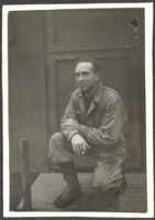 H. H. West, Jr. kneels and poses in front of his barracks at Fort Mears (photo, recto), Dutch Harbor, 1942