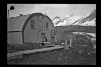 Two servicemen stand outside the quarters of H. H. West, Jr., Dutch Harbor, 1943