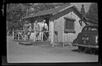 Agnes Whitaker, Mertie West and Forrest Whitaker stand outside their cabin at Lighthouse Camp, Big Bear Lake, 1943