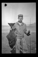PFC H. H. West, Jr. poses with halibut, Aleutian Islands, 1943