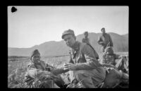 Mark Schwandt, H. H. West, Jr., Flintrop, Tempie and Bender relax in a field, Aleutian Islands, 1943