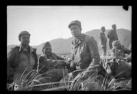 Phil Cohen, Mark Schwandt, H. H. West, Jr., Flintrop, Tempie and Bender relax in a field, Aleutian Islands, 1943