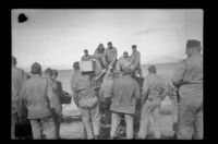 Servicemen load a boat to head back to camp, Aleutian Islands, 1943