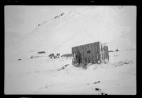 Hut sitting at the base of a snowy mountainside, Attu Island, 1944