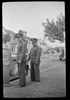 H. H. West, Jr. and Walter Burgess stand beside the car outside H. H. West's residence, Los Angeles, 1945