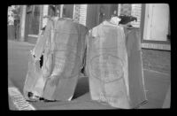 Two boxes of Stakmore folding chairs sit on the sidewalk outside the H. H. West Company, Los Angeles, 1945