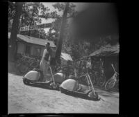 Robert Tibbals stands outside his bike and scooter rental business, Big Bear Lake, 1945