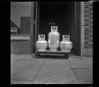 Three gas tanks sit atop a dolly outside the H. H. West Company offices on Omar Avenue, Los Angeles, 1946