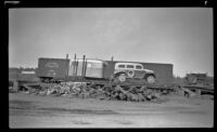 Car and trailer sit atop a flatbed car at the railroad yard, Anchorage, 1946