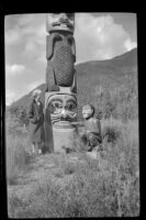 Mertie West poses next to a totem pole at Saxman Totem Park, Saxman, 1946
