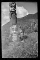 H. H. West poses next to a totem pole at Saxman Totem Park, Saxman, 1946