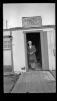 Mertie West stands in the front doorway of the Shawcreek Lodge, [Delta Junction vicinity?], 1946