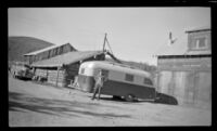 H. H. West poses beside a Westcraft Trailer, Circle vicinity, 1946
