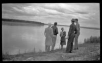 Mertie West and 4 others stand along the bank of the Yukon River, Circle, 1946