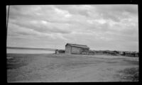 Distant view of buildings standing near the bank of the Yukon River, Circle, 1946