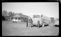 Mertie West and other bus passengers stand in front of their bus, Gulkana, 1946