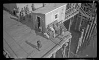 Bird's-eye view of dockworkers anchoring the ship to the dock, Metlakatla, 1946