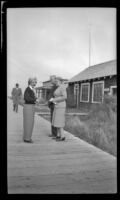 Mertie West and 2 fellow ship passengers stand on a walkway, Metlakatla, 1946