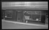 Mertie West stands in front of a shop window, Juneau, 1946