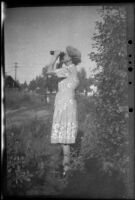 Mertie West looks through a pair of binoculars towards Cook Inlet, Anchorage, 1946