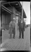 Dr. Will Reiley and Frank Iddings stand outside the Chicago, Burlington and Quincy Railroad depot, Red Oak, 1946